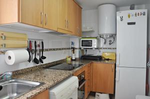 a small kitchen with a sink and a refrigerator at Apartamento Torredembarra, muy cerca de la playa! in Torredembarra