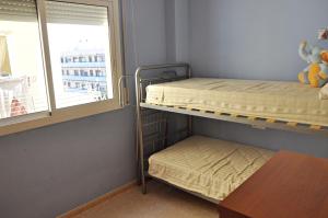 two bunk beds in a room with a window at Apartamento Torredembarra, muy cerca de la playa! in Torredembarra