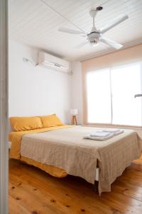 - une chambre avec un lit et un ventilateur de plafond dans l'établissement Cabañas Chaná y Timbú, à Dique Luján