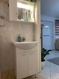 W łazience znajduje się biała umywalka i lodówka. w obiekcie Little apartment w mieście Patras