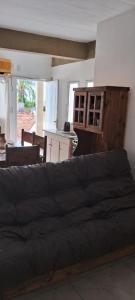 un sofá negro en una sala de estar con cocina en Dpto centrico en Bella Vista