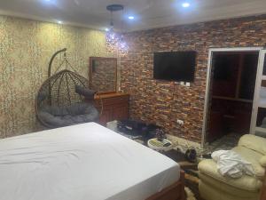 a bedroom with a bed and a brick wall at La fierté chambre in Ziguinchor