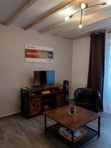 a living room with a table and a tv at Gîte Chez Pierrot - La vallée des châteaux in La Roque-Gageac