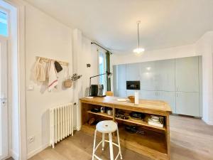 - une cuisine avec un bureau et un tabouret dans la chambre dans l'établissement La Villa Billard - 200 m2 - Jardin, à Saint-Nazaire