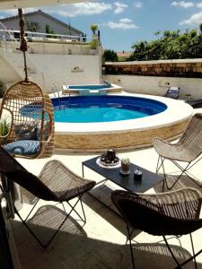 een patio met stoelen en een zwembad bij Apartments Rustika Toscana in Vodice
