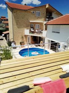 a wooden deck with a pool in front of a house at Apartments Rustika Toscana in Vodice