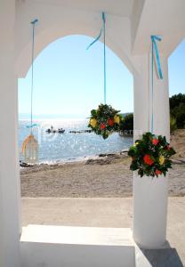 un edificio blanco con flores en la playa en Villa Tranquility - Walk to the Beach with Infinity Pool en Porto Heli