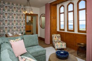 una sala de estar con un sofá y una silla en Watermouth Castle, Harbour Apartment, en Ilfracombe