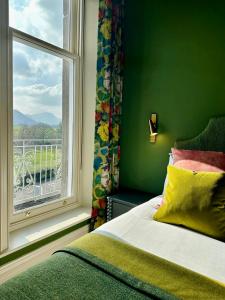 a bedroom with a bed and a window with a view at Fellpack House in Keswick