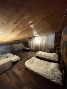 two beds in a room with wooden ceilings at Poolside Argel in Argel