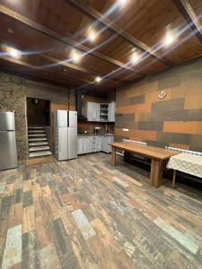 a large kitchen with a wooden table and refrigerator at Poolside Argel in Argel