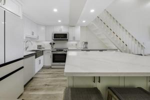 una cocina blanca con armarios blancos y una escalera en South Seas Beach Villa 2535 home, en Captiva