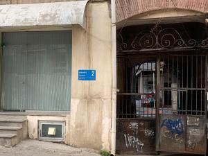 ein Gebäude mit einem blauen Schild auf der Seite in der Unterkunft Best Location Renovated Home in Tbilisi City