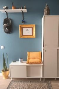 a blue room with a white refrigerator and a table at Casa da Memória in Angra do Heroísmo