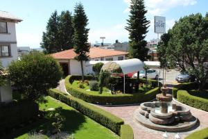 a garden with a fountain in the middle of a building at Hotel Del Angel in Apizaco