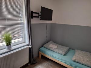 a small room with a bed and a tv and a window at Kapitän-Dallmann-Str in Bremen
