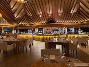 a restaurant with wooden ceilings and tables and chairs at Amaya Kuda Rah in Dhangethi