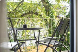 Dos sillas y una mesa en un balcón. en Alpen-Hostel Apartment Mittelstation Süd mit Motorradvermietung, en Memmingen
