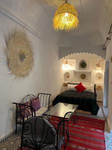 1 dormitorio con 1 cama, mesa y sillas en Riad Ago, en Marrakech