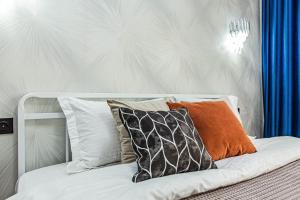 a white bed with some pillows on it at Alpine serenity deLuxe apartment with MOUNTAIN views near the ADK shopping center and Sairan METRO station in Almaty