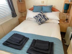 łóżko w pokoju z ręcznikami w obiekcie Static van on Smallgrove in Ingoldmells w Skegness