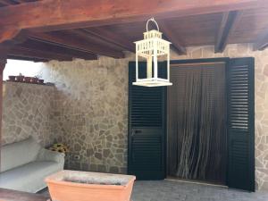 a room with a green door and a chandelier at Tenuta Nonno Carmine in Porto Cesareo