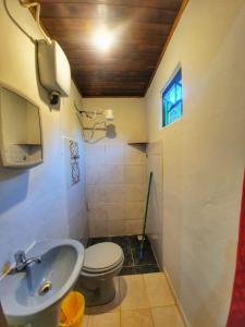 a bathroom with a sink and a toilet at Chalé e Camping Elementais in São Thomé das Letras