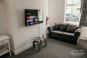 a living room with a couch and a tv at Dover St by Prestige Properties SA in Barrow in Furness