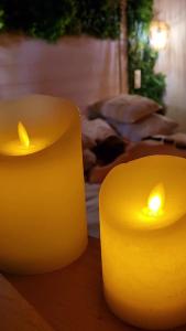 勒格羅－迪魯瓦的住宿－Les Spas de la mer, Suite & Spa, Love room, Plein Cœur du Grau，两把黄蜡烛坐在桌子上