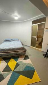 um quarto com uma cama e um tapete colorido em Departamento amplio céntrico em Huaraz