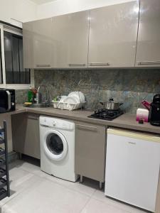 cocina con lavadora y fogones en Appartement 3 pièces, en Épinay-sur-Seine