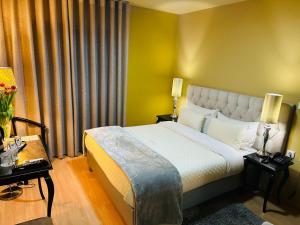 um quarto de hotel com uma cama e uma parede amarela em Hotel Tulipa em Bragança