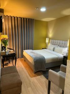 a bedroom with a king sized bed and a couch at Hotel Tulipa in Bragança