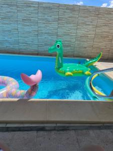 een zwembad met twee dinosaurussen in het water bij Appartement BALISIER in Saint-François