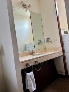 uma casa de banho com um lavatório, um espelho e uma toalha em Duplex Vintage en el corazón de Miraflores em Lima
