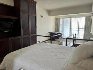 um quarto com uma cama, uma secretária e uma varanda em Duplex Vintage en el corazón de Miraflores em Lima