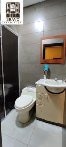 y baño con aseo y lavamanos. en HOTEL BRAVO GRAND HOTEL, en Quevedo