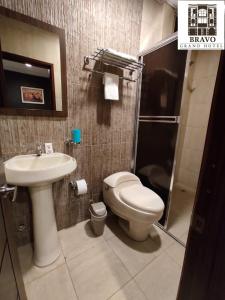 a bathroom with a toilet and a sink and a shower at HOTEL BRAVO GRAND HOTEL in Quevedo