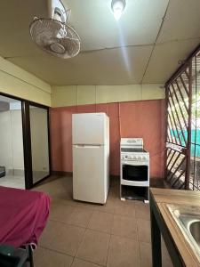 a kitchen with a white refrigerator and a stove at Wide Mouth Frog Conchal in Brasilito