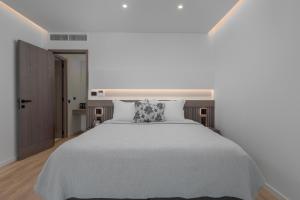 a bedroom with a large white bed with a pillow at Adrina Grand Hotel in Panormos Skopelos