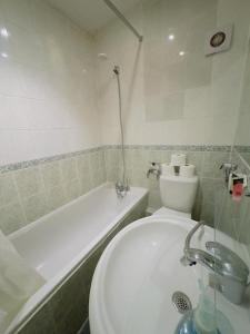a bathroom with a white toilet and a bath tub at Bright Budget Studio Apartment In Central London in London