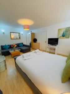 a bedroom with a large bed and a living room at Bright Budget Studio Apartment In Central London in London