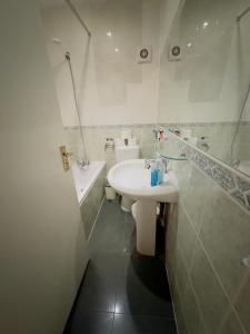 a white bathroom with a sink and a toilet at Bright Budget Studio Apartment In Central London in London