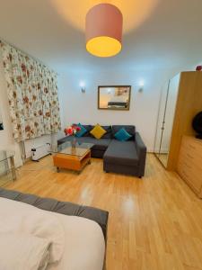 a living room with a couch and a table at Bright Budget Studio Apartment In Central London in London