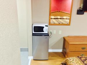 a microwave sitting on top of a refrigerator in a room at Deluxe Inn in West Memphis