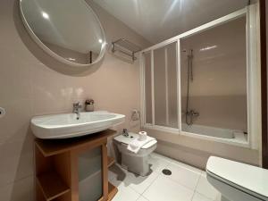 Un baño con lavabo, inodoro y espejo. en HOME GV35 By Oktheway, en Sarria