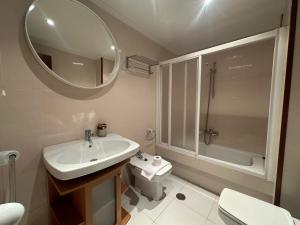 Un baño con lavabo, inodoro y espejo. en HOME GV35 By Oktheway, en Sarria 18 fotos más