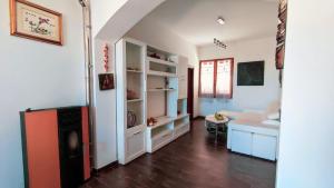 uma sala de estar com paredes brancas e pisos em madeira em Casa Cristoforo Colombo em Sorso
