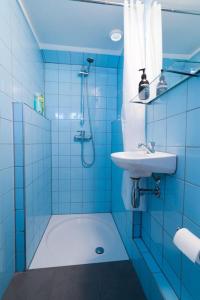 uma casa de banho azul com um lavatório e um chuveiro em Island Sleeping em Aalsmeer