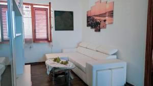 uma sala de estar com um sofá branco e uma mesa em Casa Cristoforo Colombo em Sorso